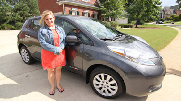 Allison Howard with her Nissan Leaf, the Nissan-Renault Alliance's 100,000th electric car
