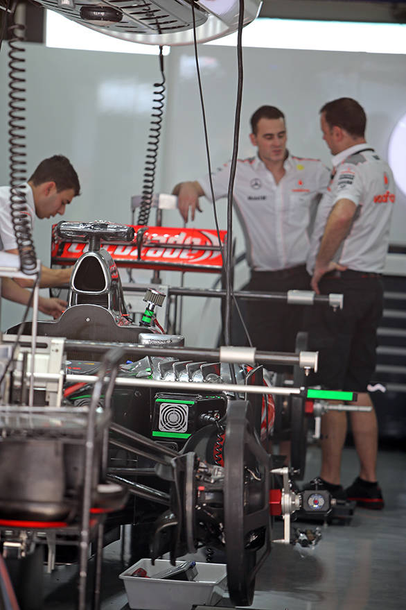 McLaren team personnel assembling the cars for Checo and Jenson
