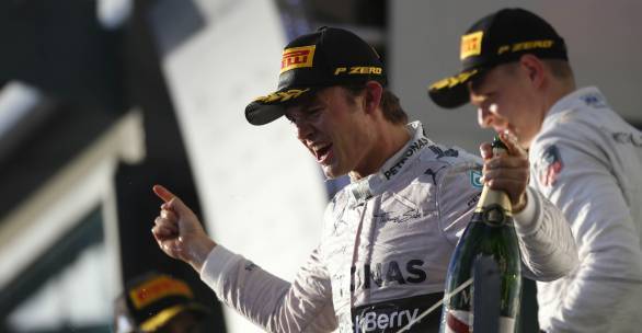 Nico Rosberg celebrates winning the first race of the 2014 F1 season while Kevin Magnussen looks on