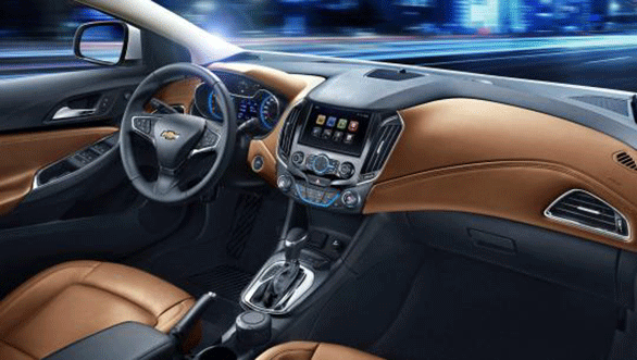 the insides upholstered in saddle brown leather, accented with chrome and a deep black trim. Even the three-spoked steering wheel comes wrapped in leather