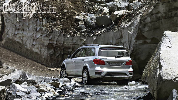 The GL inches across a dicey river crossing with precariously perched boulders just waiting to collapse onto the road