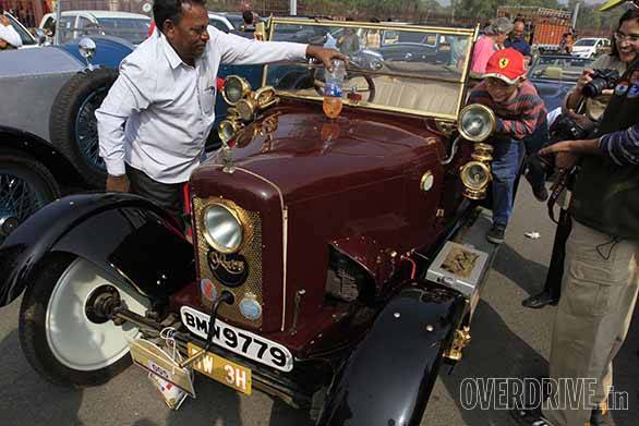 Fali Dhondy's Rover 8 being refueled. Learners car complete with two steering wheels and set of pedals. A war model amphibian vehicle. A 1936 Rolls-Royce Phantom III dominating the streets of Delhi