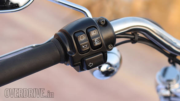 The left side switches of the Harley-Davidson 1200 Custom include the digital readout toggle (circular emblem), horn, headlight beam and left side indicator switches
