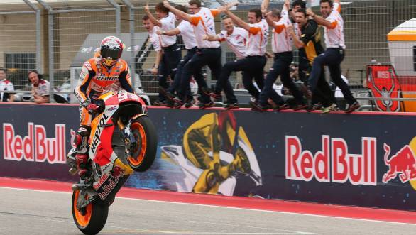 Marc Marquez celebrates his fourth consecutive victory at the Circuit of the Americas, as his Honda team cheers from the pit wall