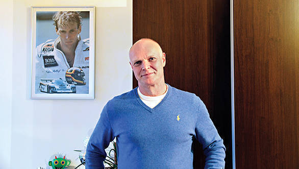 Georg Bellof in his home in Giessen, with a photo of his brother Stefan hanging behind him