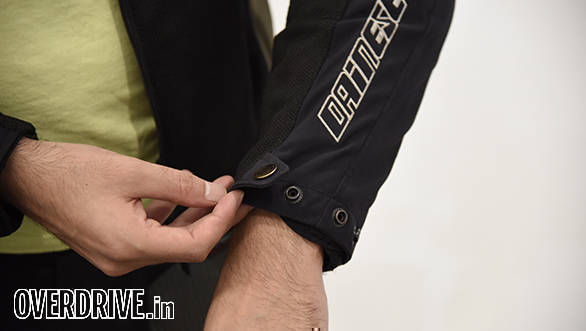 Snap-fit buttons adjust the wrist tightness. I find that the first position fits best